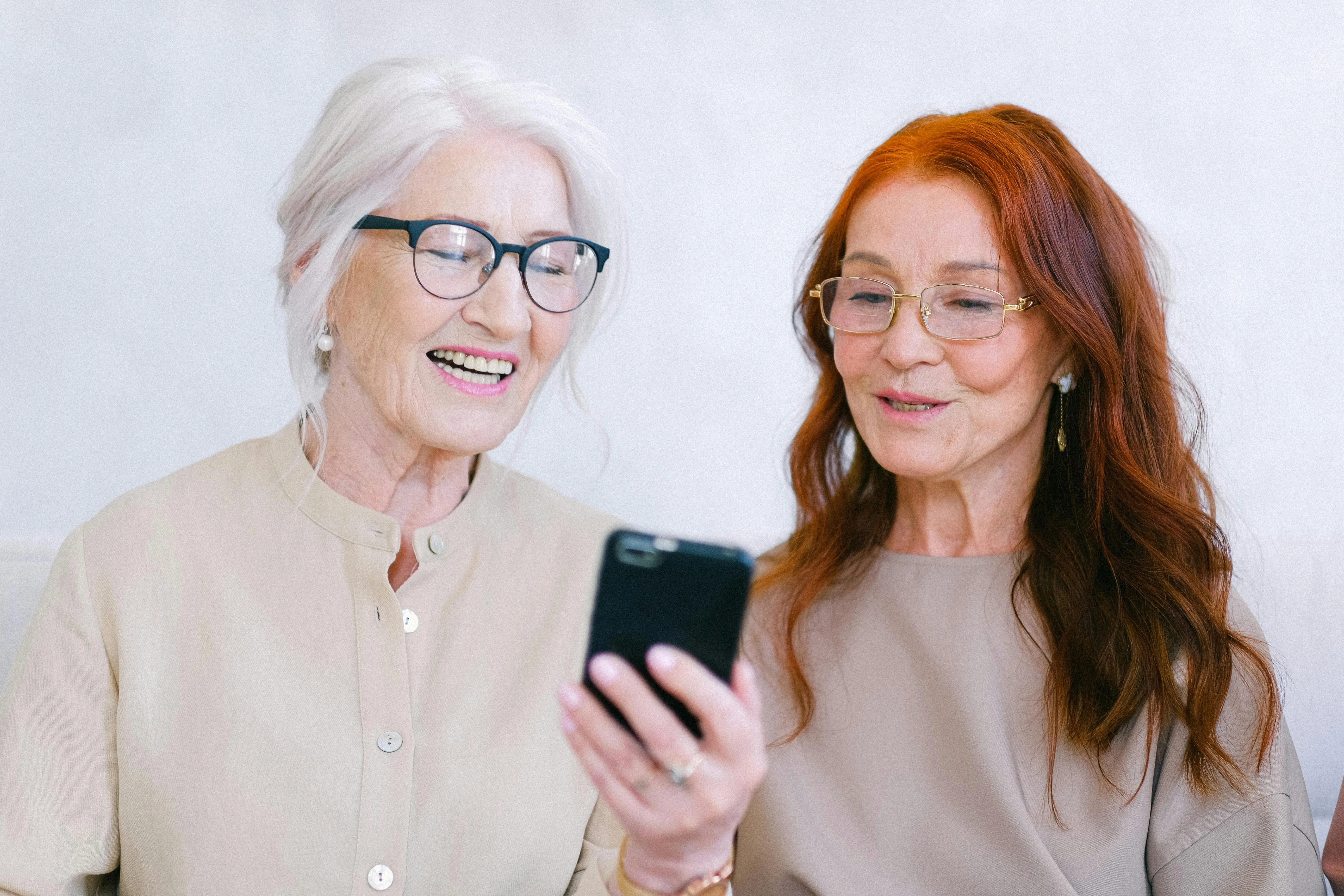 des jumelles regardant un téléphone en riant