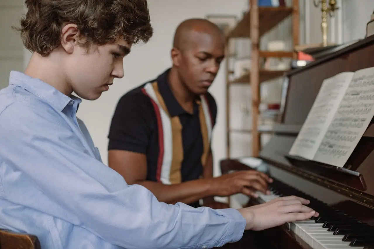 Une proffesseur de piano apprenant à une jeune fille comment jouer